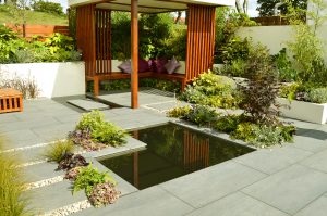 Low maintenance garden with a stone patio and ornamental garden pond