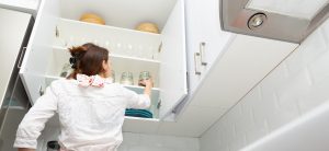 Women Picking An Item From Storage Hutch. Smart Kitchen Storage