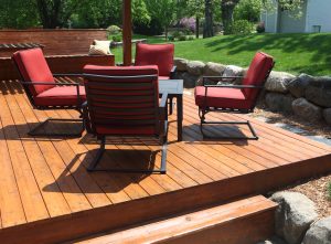 Backyard deck design with furniture on freshly stained deck.